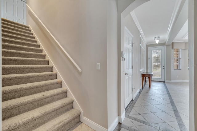 stairway featuring crown molding and tile patterned floors