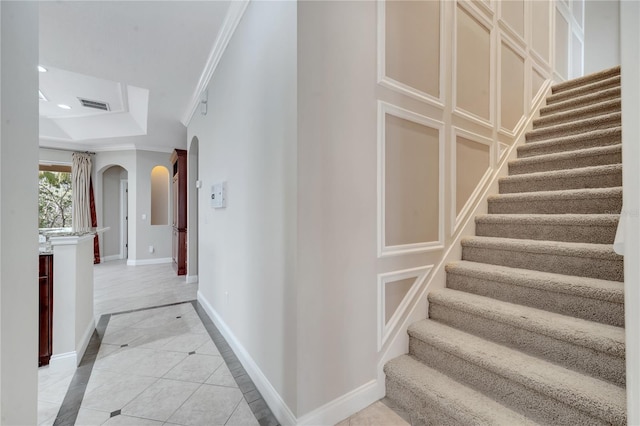 staircase featuring tile patterned flooring and crown molding