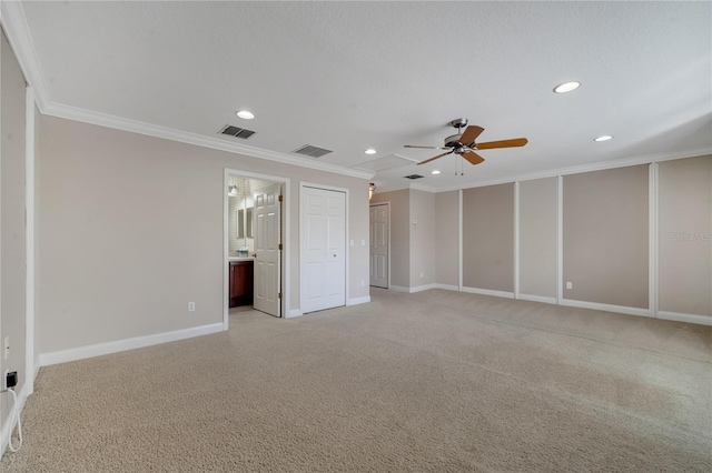 unfurnished bedroom featuring ornamental molding, light carpet, two closets, and ensuite bath