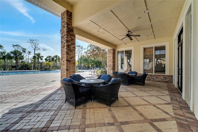 view of patio with ceiling fan, a community pool, and outdoor lounge area