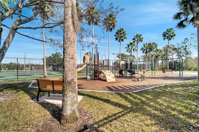 view of play area featuring a lawn and tennis court