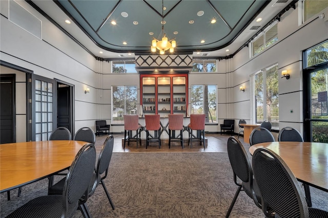 dining space featuring plenty of natural light, a towering ceiling, and a chandelier