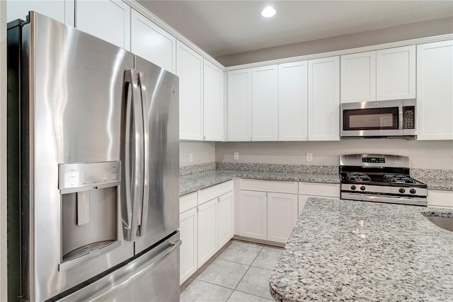 15574 Murcott Blossom Blvd, Winter Garden, FL 34787 - kitchen with stainless steel appliances, light tile patterned flooring, white cabinets, recessed lighting, and light stone counters
