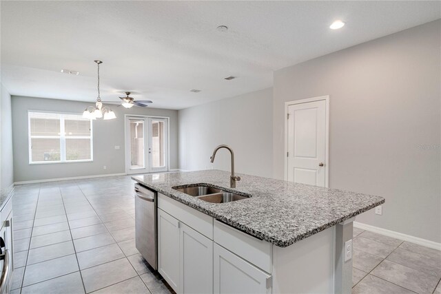 15574 Murcott Blossom Blvd, Winter Garden, FL 34787 - kitchen with dishwasher, light tile patterned flooring, light stone countertops, an island with sink, and white cabinets