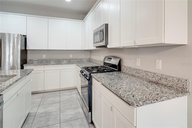 15574 Murcott Blossom Blvd, Winter Garden, FL 34787 - kitchen with stainless steel appliances, white cabinetry, light stone counters, and light tile patterned floors