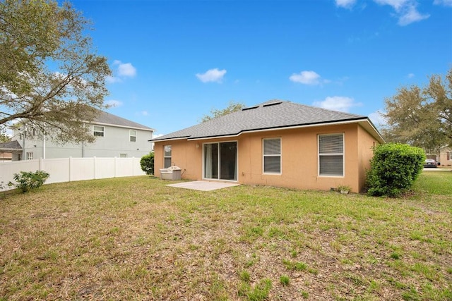 rear view of house featuring a yard and a patio