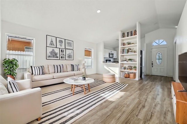 living room featuring vaulted ceiling and light hardwood / wood-style floors