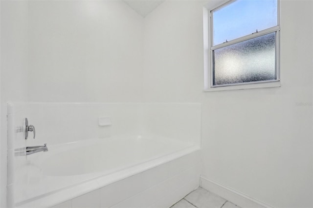 bathroom with tiled bath and tile patterned floors