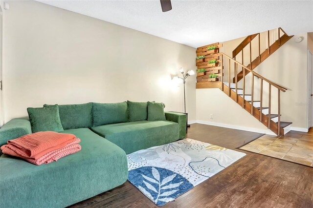 living room featuring ceiling fan, hardwood / wood-style floors, and a textured ceiling