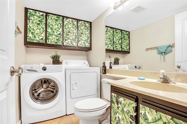 bathroom featuring vanity, toilet, and washer and dryer