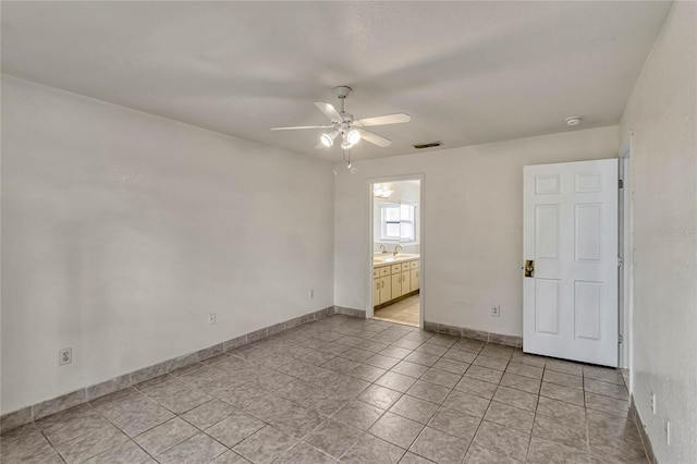 empty room featuring a sink, baseboards, visible vents, and a ceiling fan