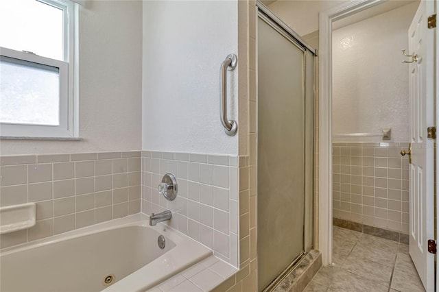 full bathroom featuring a jetted tub, a stall shower, and tile patterned floors