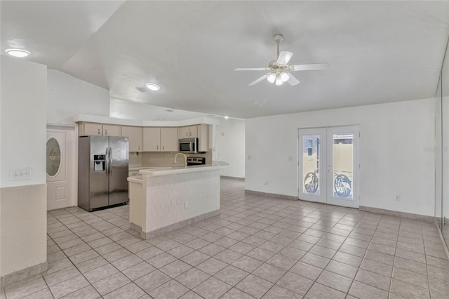 kitchen featuring open floor plan, cream cabinets, stainless steel appliances, light countertops, and french doors