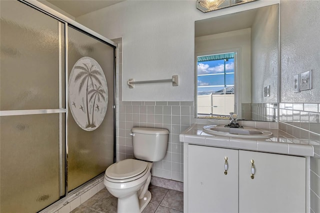 full bath featuring toilet, tile patterned floors, vanity, a shower stall, and tile walls