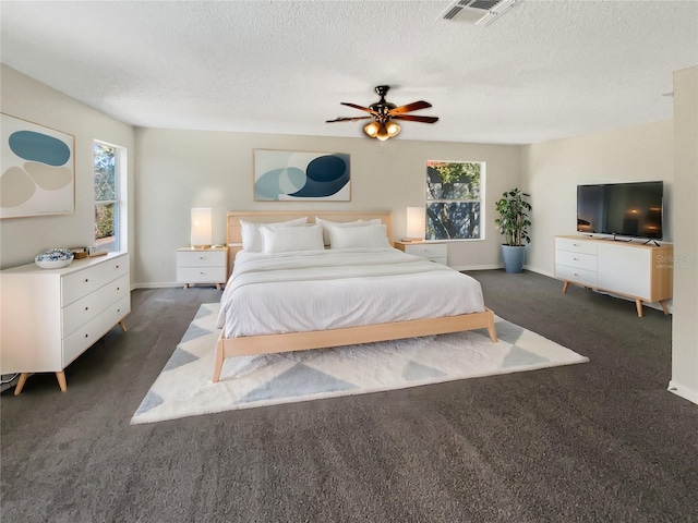 carpeted bedroom featuring ceiling fan and a textured ceiling