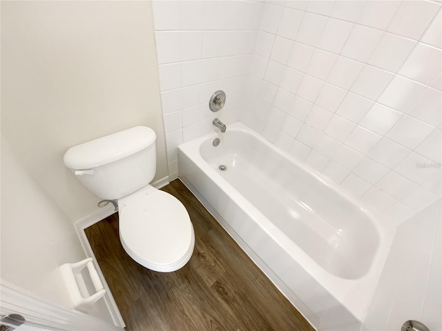 bathroom with tiled shower / bath combo, wood-type flooring, and toilet