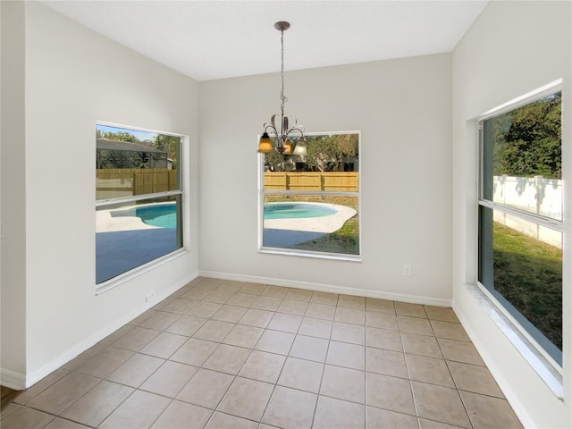 unfurnished dining area featuring light tile patterned flooring and a chandelier