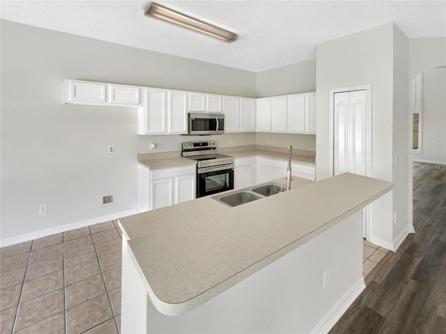 kitchen featuring appliances with stainless steel finishes, sink, a center island with sink, and white cabinets