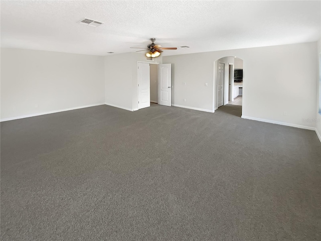 unfurnished room with dark colored carpet, ceiling fan, and a textured ceiling