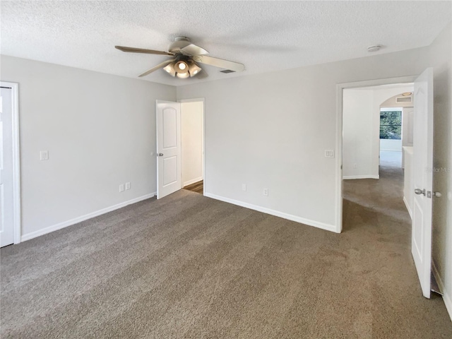 carpeted spare room with ceiling fan and a textured ceiling