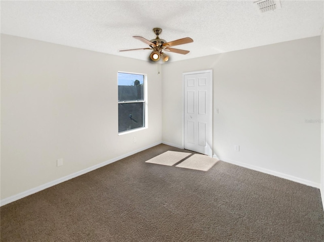 carpeted spare room with ceiling fan and a textured ceiling