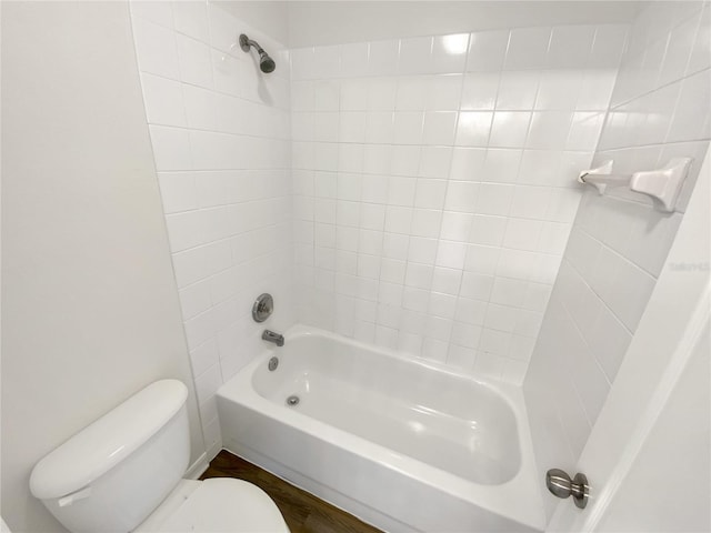 bathroom featuring tiled shower / bath combo and toilet