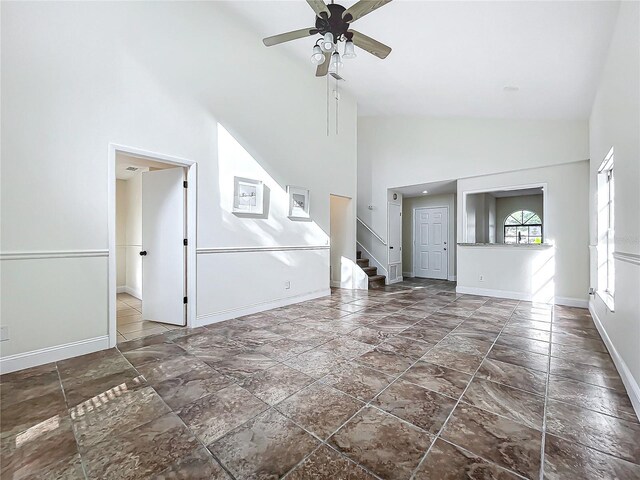 1970 Larkwood Dr, Apopka, FL 32703 - unfurnished living room with high vaulted ceiling, ceiling fan, baseboards, and stairway