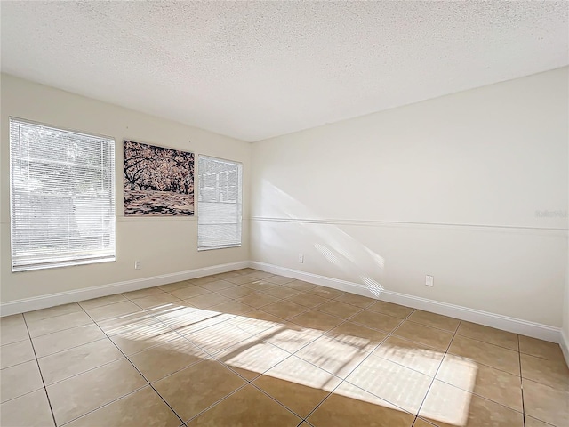 1970 Larkwood Dr, Apopka, FL 32703 - spare room featuring a textured ceiling, light tile patterned floors, and baseboards