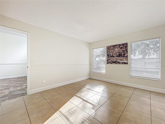 1970 Larkwood Dr, Apopka, FL 32703 - tiled empty room with a textured ceiling and baseboards