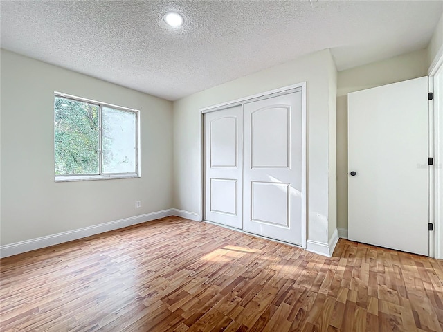 1970 Larkwood Dr, Apopka, FL 32703 - unfurnished bedroom featuring a closet, baseboards, wood finished floors, and a textured ceiling