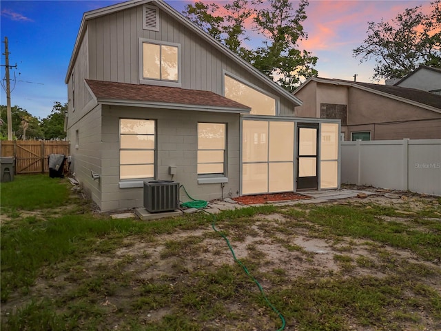 1970 Larkwood Dr, Apopka, FL 32703 - back of property at dusk featuring a fenced backyard, cooling unit, and roof with shingles