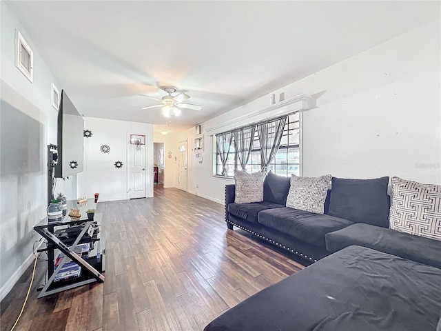 living room with dark wood-type flooring and ceiling fan