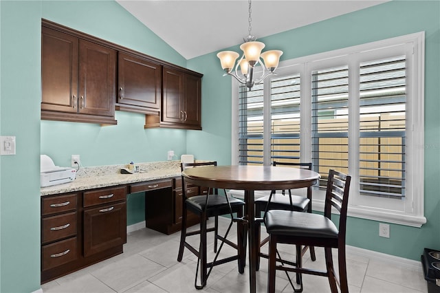 kitchen with light stone countertops, dark brown cabinets, lofted ceiling, and decorative light fixtures