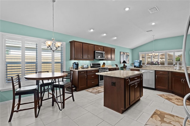 kitchen with decorative light fixtures, a chandelier, dark brown cabinets, stainless steel appliances, and light stone countertops