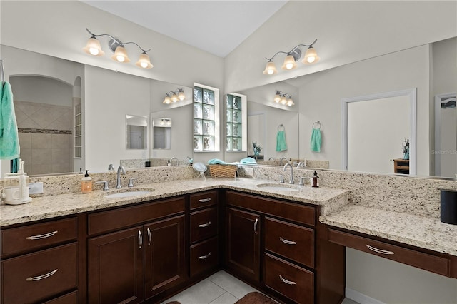 bathroom with tile patterned flooring, vanity, and walk in shower