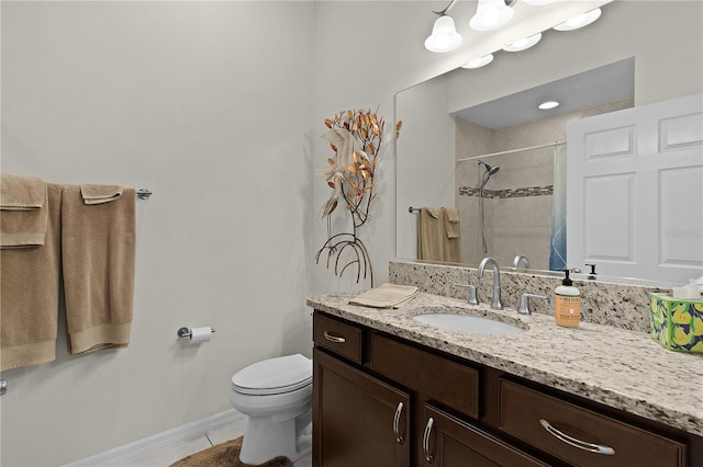 bathroom featuring vanity, a tile shower, tile patterned floors, and toilet