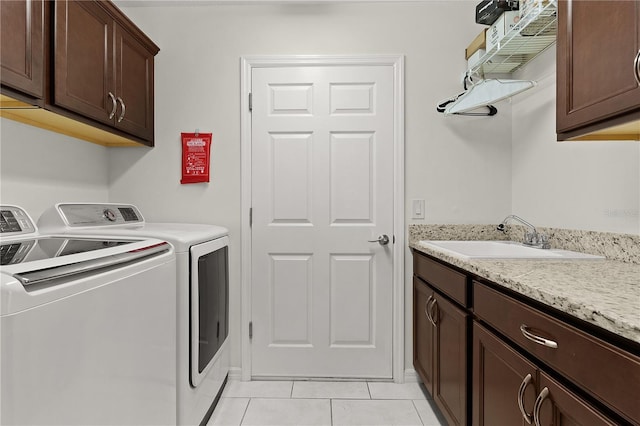 laundry area with separate washer and dryer, sink, light tile patterned floors, and cabinets