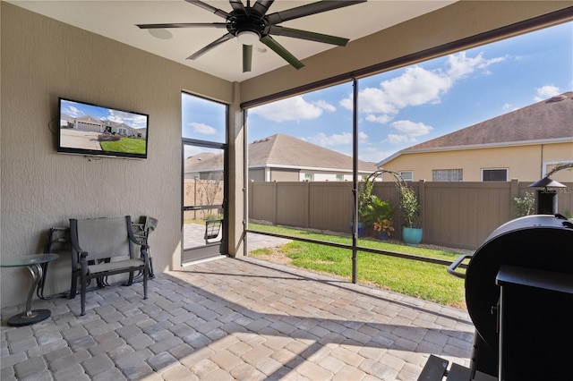 sunroom / solarium featuring ceiling fan