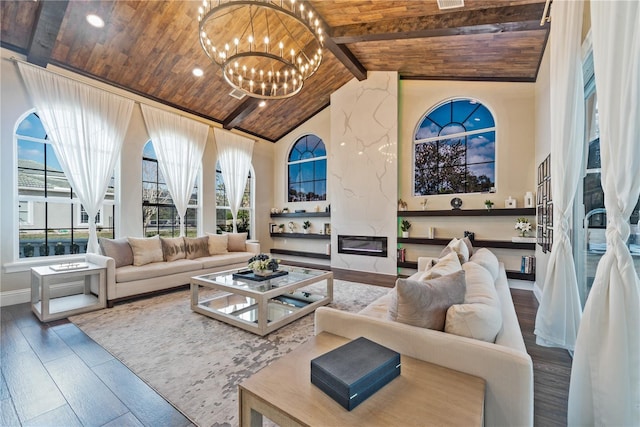 sunroom with vaulted ceiling with beams, wooden ceiling, a premium fireplace, and a notable chandelier