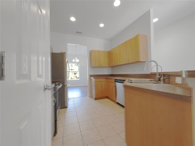 kitchen with appliances with stainless steel finishes, light brown cabinetry, sink, and light tile patterned floors