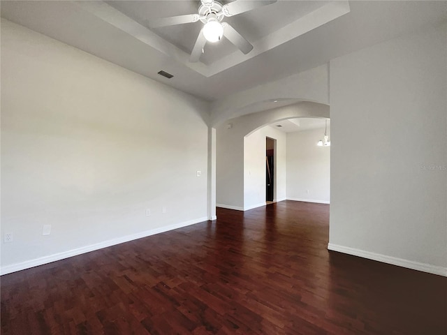 spare room featuring ceiling fan, dark hardwood / wood-style flooring, and a tray ceiling