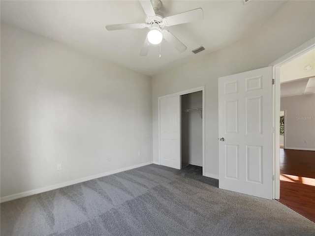 unfurnished bedroom with dark colored carpet, ceiling fan, and a closet