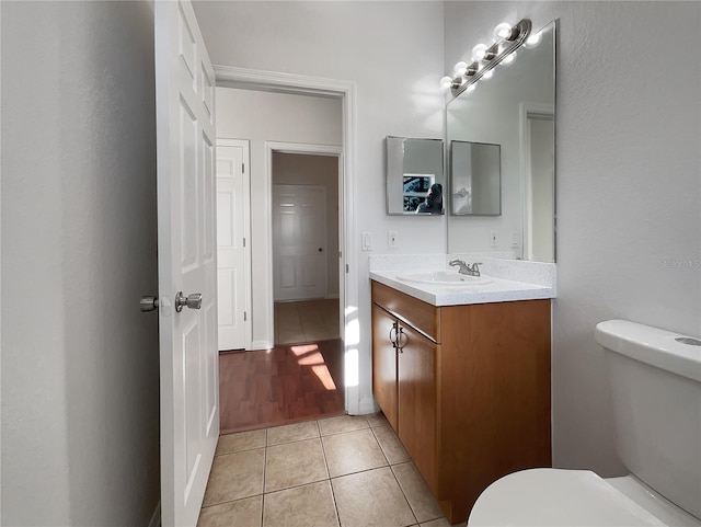 bathroom featuring tile patterned flooring, vanity, and toilet