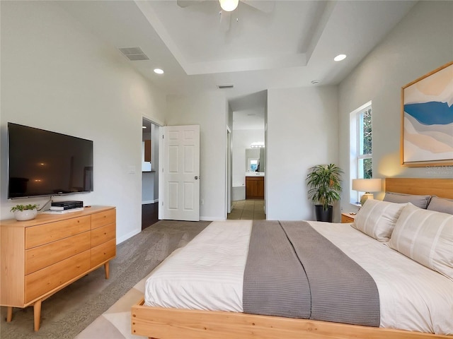 bedroom featuring ceiling fan, carpet flooring, connected bathroom, and a raised ceiling