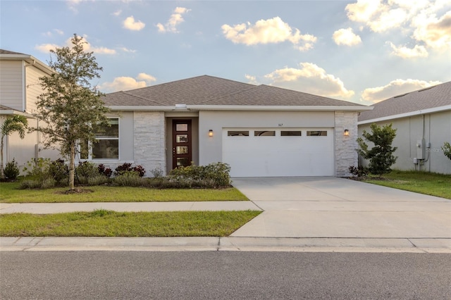 prairie-style home with a garage and a front lawn