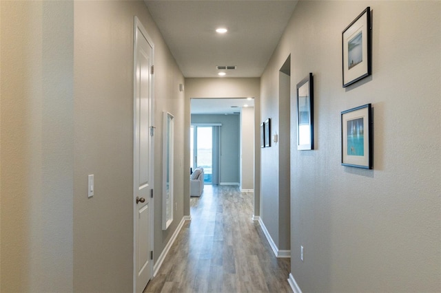 corridor with light hardwood / wood-style flooring