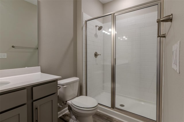 bathroom featuring an enclosed shower, vanity, hardwood / wood-style flooring, and toilet