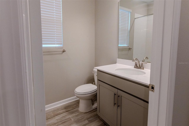 bathroom featuring hardwood / wood-style flooring, vanity, toilet, and walk in shower