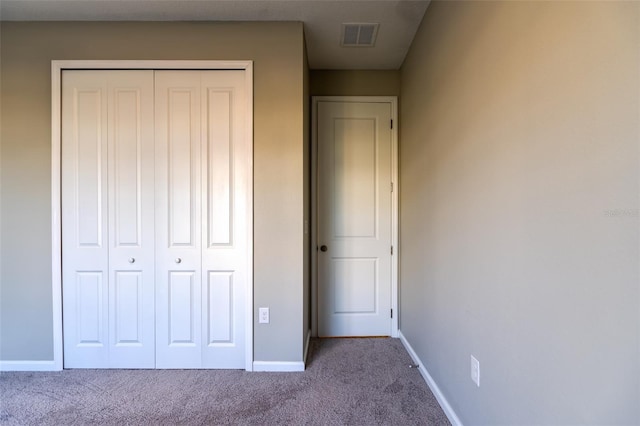 unfurnished bedroom featuring light colored carpet and a closet