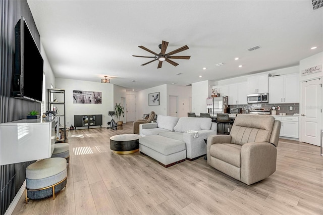 living room featuring ceiling fan and light wood-type flooring